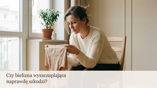 Kobieta ogląda beżową bieliznę modelującą siedząc przy oknie